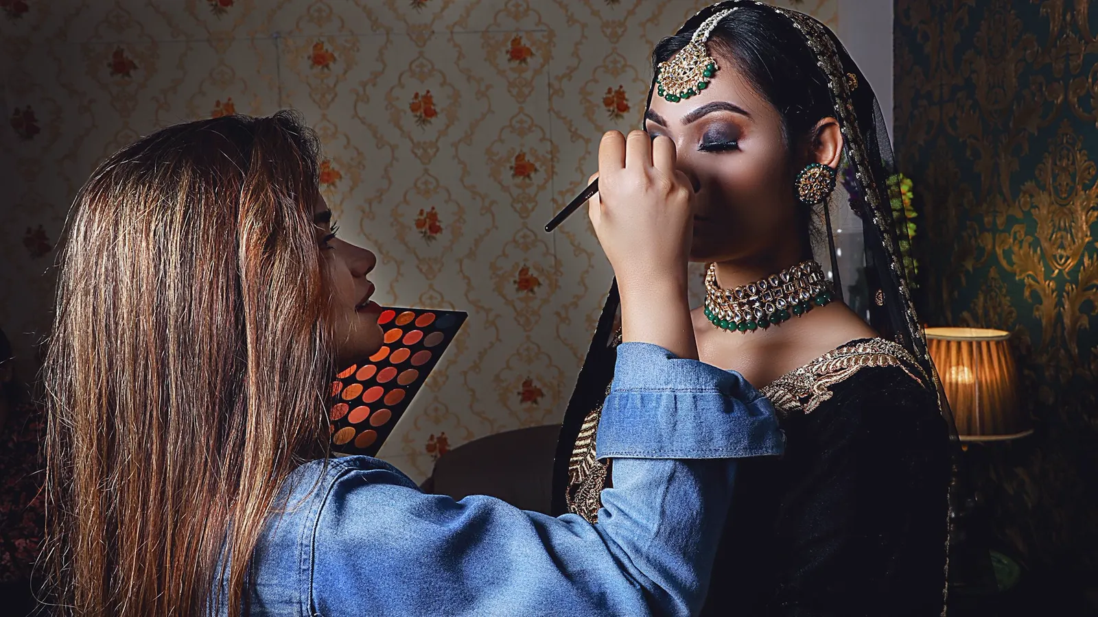 A makeup artist working on a client at the client's own home