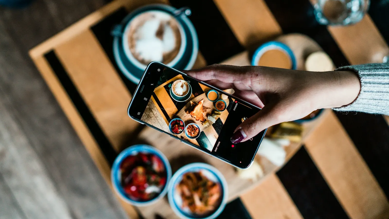 Someone photographing a spread of food from above with a phone