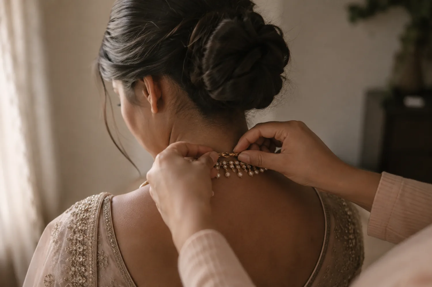 A necklace being fastened at the nape